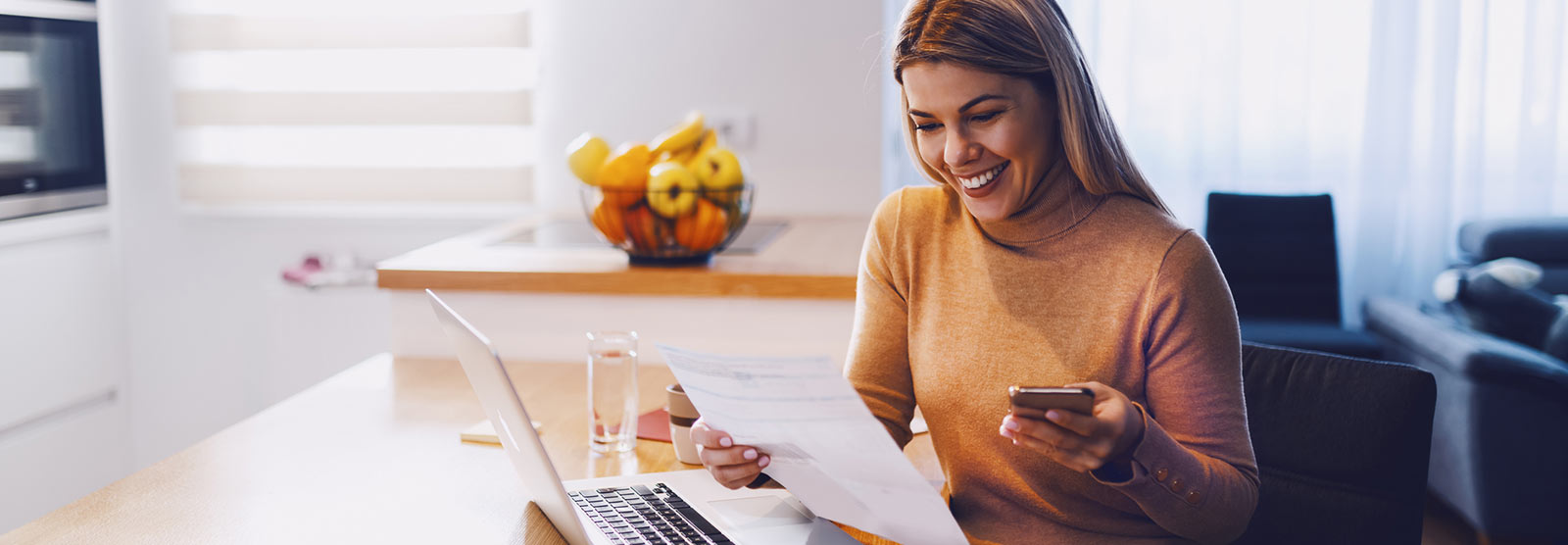 Lady using a smartphone and laptop computer to view finances