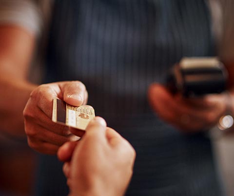 Person using a debit card at a store front